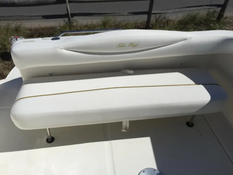 Slide: The Image of 2001 Sea Ray 280 Sundancer boat seating, white upholstery, outdoor setting. - 30