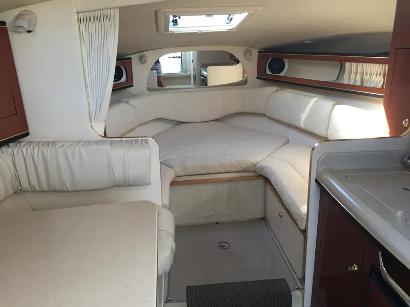Slide: The Image of 2001 Sea Ray 280 Sundancer cabin interior with cozy seating and compact kitchenette. - 31