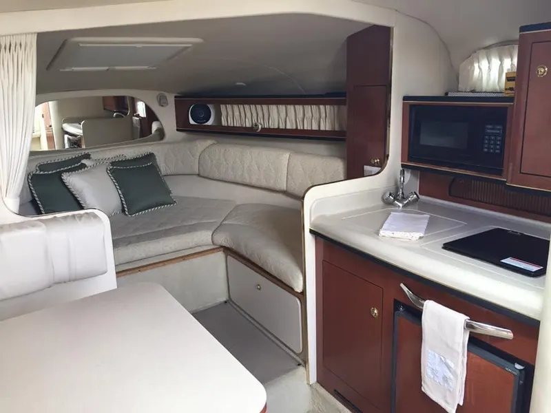 Slide: The Image of Interior of 2001 Sea Ray 280 Sundancer with cozy seating and kitchenette. - 9