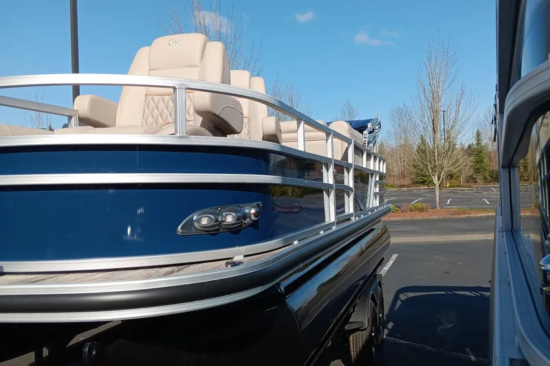 The Image of 2024 Ranger Reata 220FC pontoon boat with blue exterior and beige seating. - 0