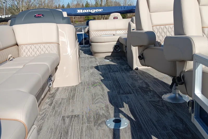 Slide: The Image of 2024 Ranger Reata 220FC boat interior with beige leather seats and gray flooring. - 2