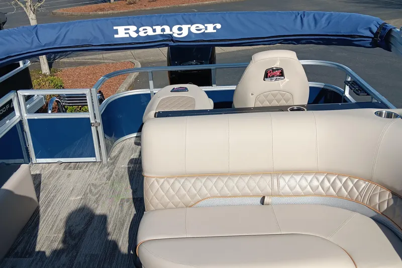 Slide: The Image of 2024 Ranger Reata 220FC boat interior with beige seating and blue canopy. - 4