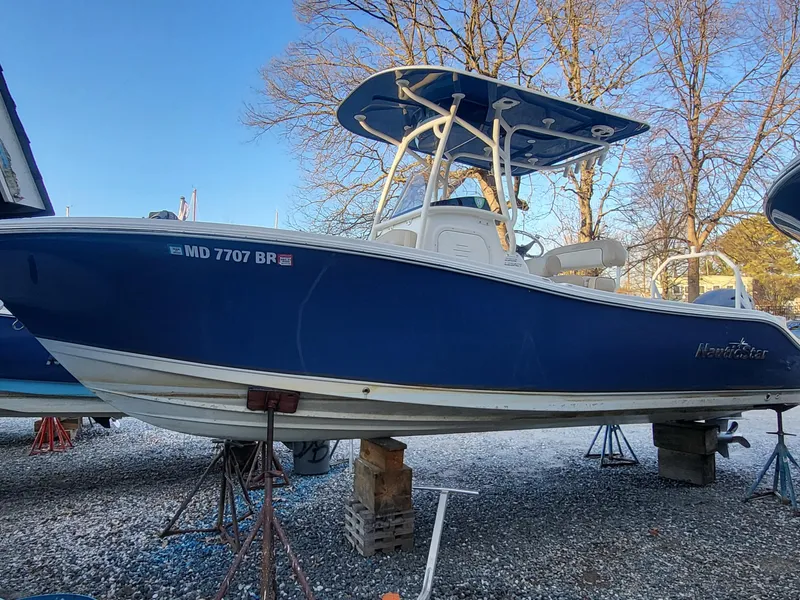 The Image of 2021 NauticStar 2302 Legacy boat in blue, on stands, outdoors. - 0