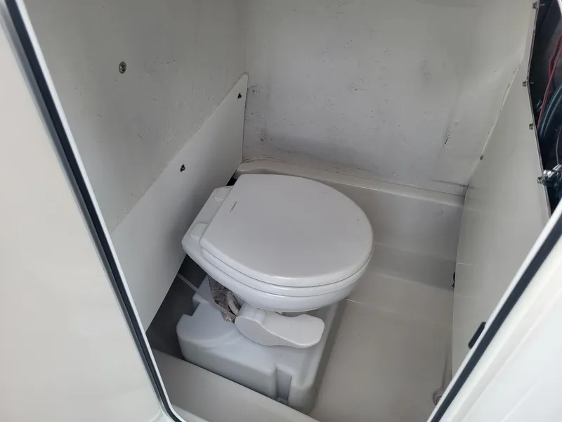 Slide: The Image of 2021 NauticStar 2302 Legacy boat interior with marine toilet. - 15