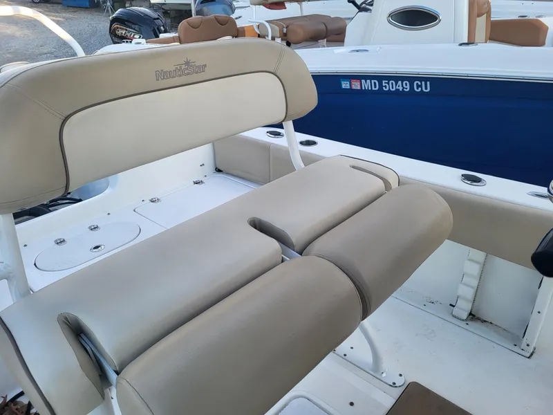 Slide: The Image of 2021 NauticStar 2302 Legacy boat with beige seating and blue hull. - 18
