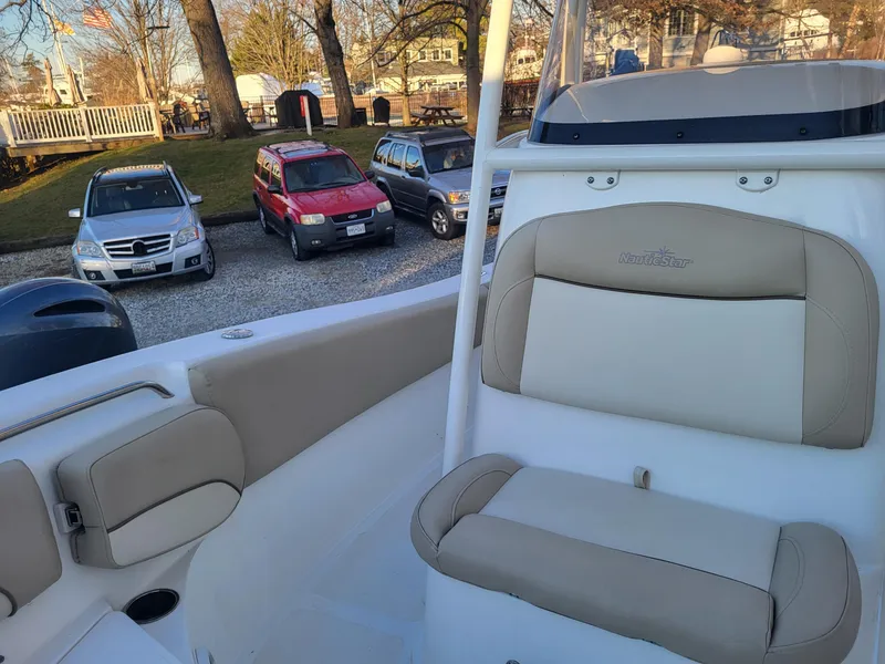 Slide: The Image of 2021 NauticStar 2302 Legacy boat interior with beige seating. - 21