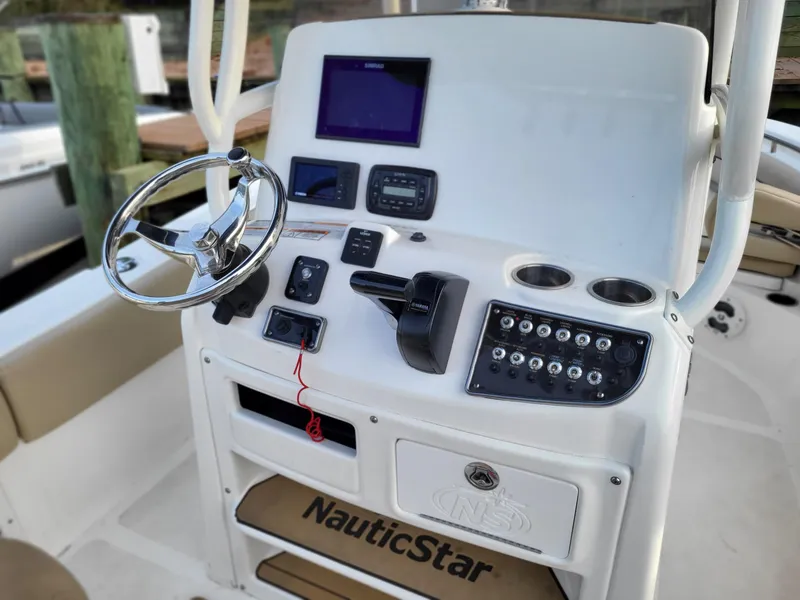 Slide: The Image of 2021 NauticStar 2302 Legacy boat console with steering wheel, controls, and navigation equipment. - 6