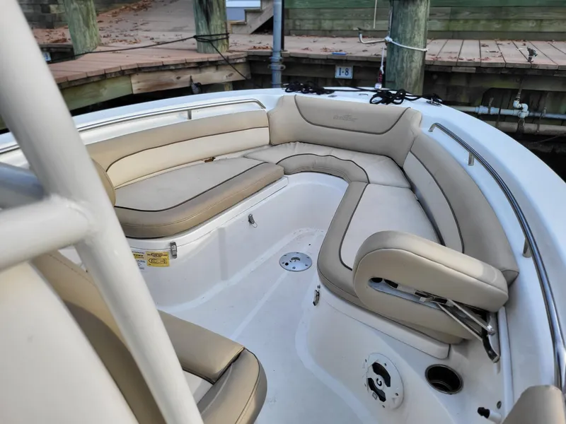 Slide: The Image of 2021 NauticStar 2302 Legacy boat with beige cushioned seating in the bow area. - 7