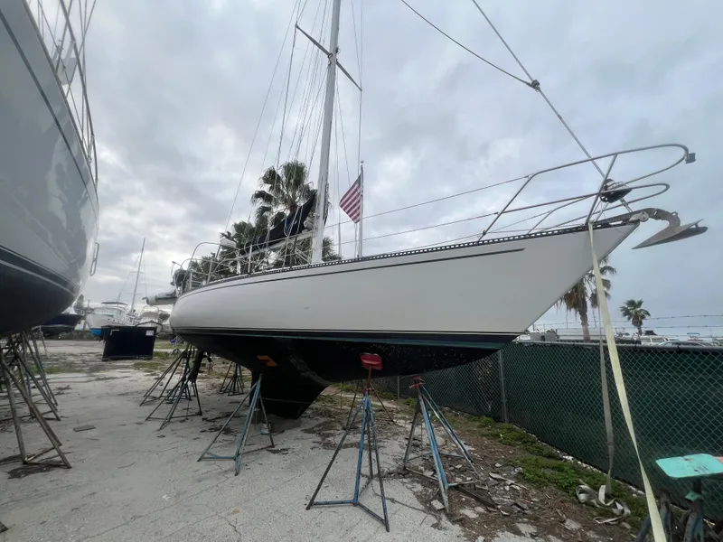 The Image of 1985 Catalina 38 sailboat on stands in a boatyard, overcast sky. - 0
