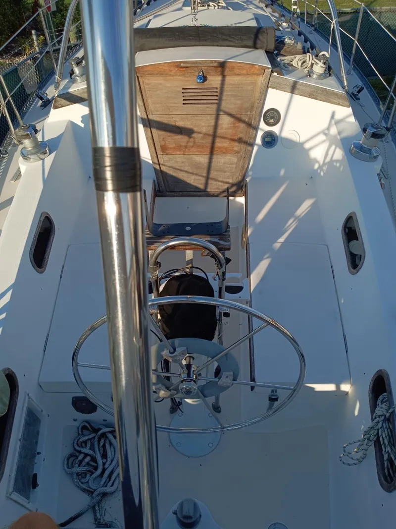 Slide: The Image of 1985 Catalina 38 sailboat cockpit with steering wheel and wooden hatch. - 12