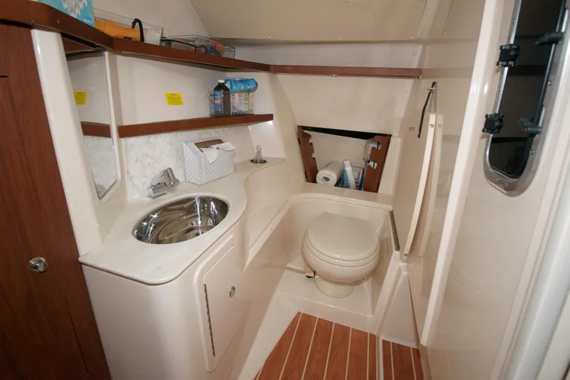 Slide: The Image of 2019 Grady-White Freedom 325 boat bathroom with sink, toilet, and storage shelves. - 16