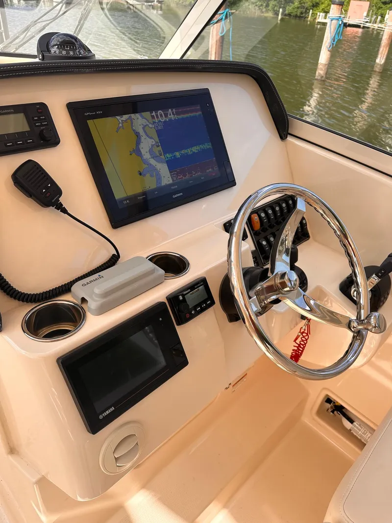 Slide: The Image of 2019 Grady-White Freedom 325 boat dashboard with navigation system and steering wheel. - 3