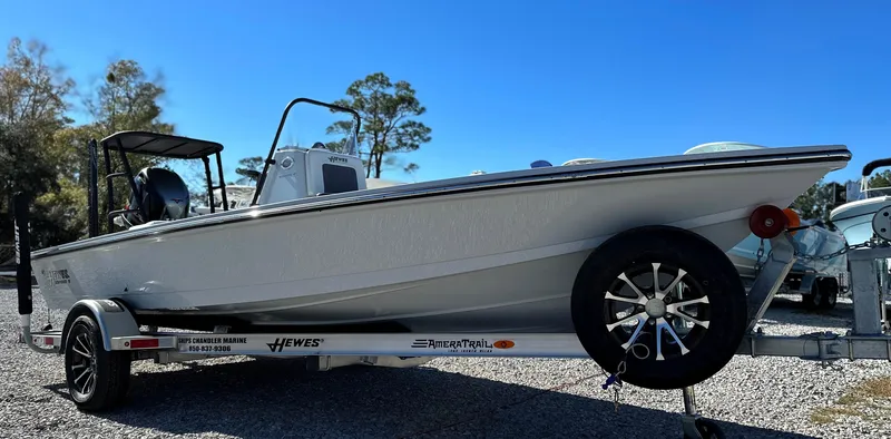 Slide: The Image of 2024 Hewes 18 Redfisher boat on trailer, side view under clear blue sky. - 7