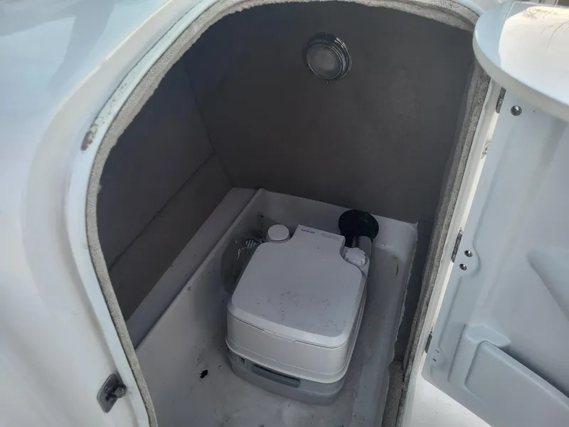 Slide: The Image of 2020 NauticStar 223DC Sport Deck boat interior with portable toilet. - 5