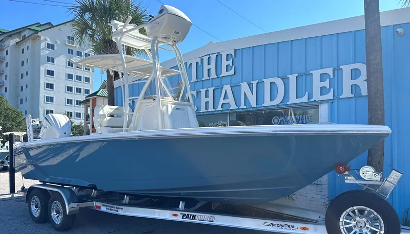 Slide: The Image of 2025 Pathfinder 2400 Open boat on trailer outside a blue building. - 1