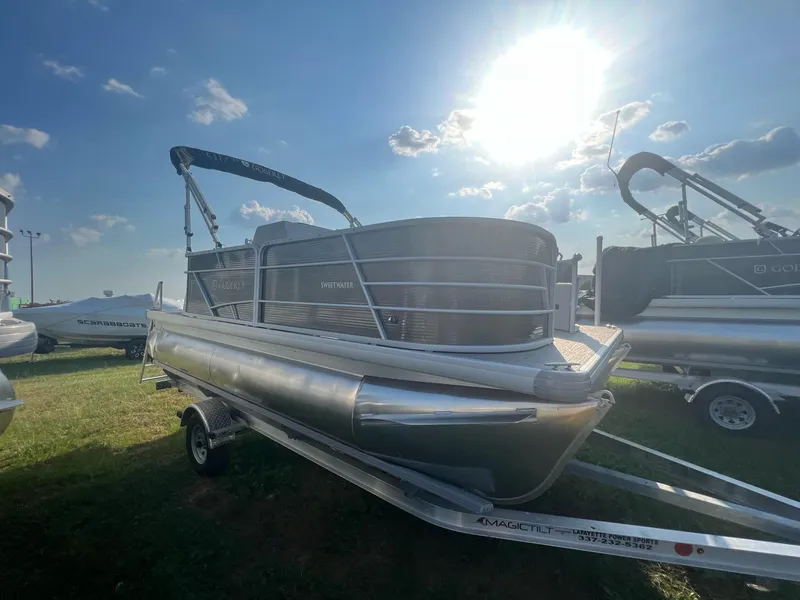 Slide: The Image of 2023 Godfrey Sweetwater Xperience 1680 FX pontoon boat on trailer under sunny sky. - 14