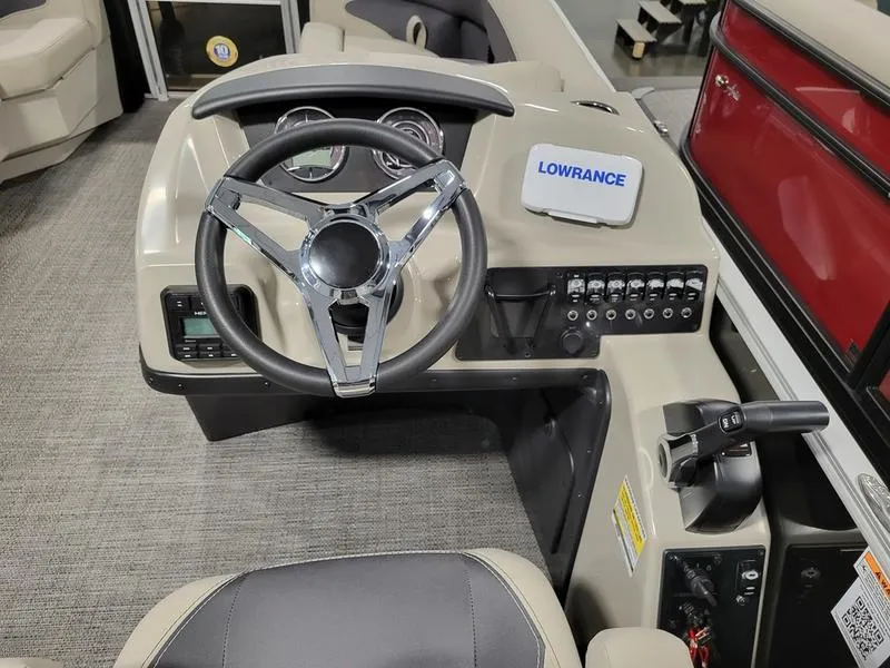 Slide: The Image of 2024 Barletta Aria A22CC boat dashboard with steering wheel and Lowrance navigation system. - 12