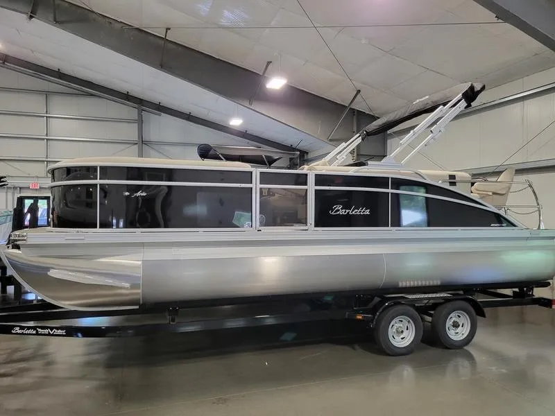 Slide: The Image of 2024 Barletta Aria A22CC pontoon boat on trailer in indoor showroom. - 2
