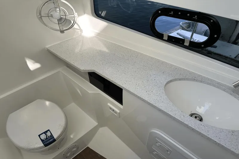 Slide: The Image of Modern bathroom in 2023 Aquila 32 Sport boat with toilet, sink, and countertop. - 15