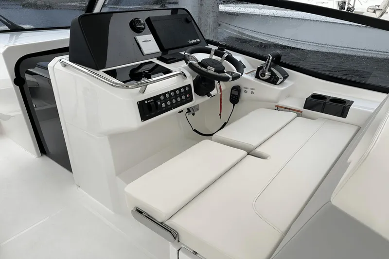 Slide: The Image of 2023 Aquila 32 Sport boat cockpit with modern steering and control panel. - 16
