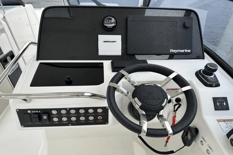 Slide: The Image of Control panel of 2023 Aquila 32 Sport boat with steering wheel and navigation equipment. - 17