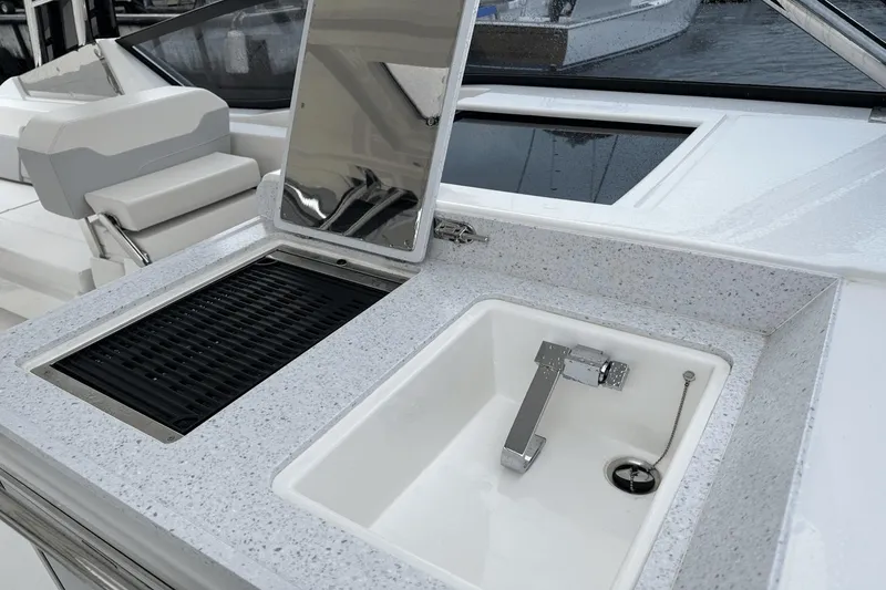 Slide: The Image of Outdoor kitchen on 2023 Aquila 32 Sport boat with sink and grill. - 20