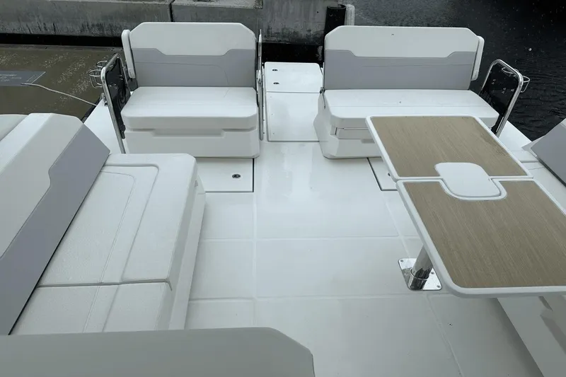 Slide: The Image of Spacious deck of 2023 Aquila 32 Sport with white seating and wooden table. - 28