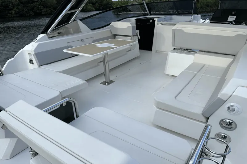 Slide: The Image of 2023 Aquila 32 Sport boat interior with white seating and a central table. - 30