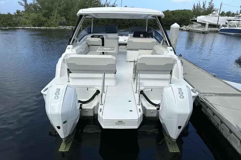 Slide: The Image of 2023 Aquila 32 Sport boat with twin Mercury 300 engines docked. - 32