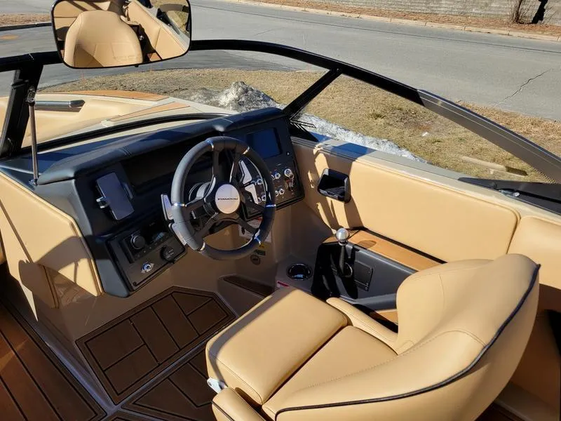 Slide: The Image of 2024 Moomba Mondo boat interior with tan leather seats and modern dashboard. - 13