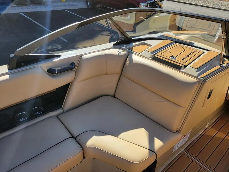 Slide: The Image of 2024 Moomba Mondo boat interior with beige seating and wooden accents. - 15