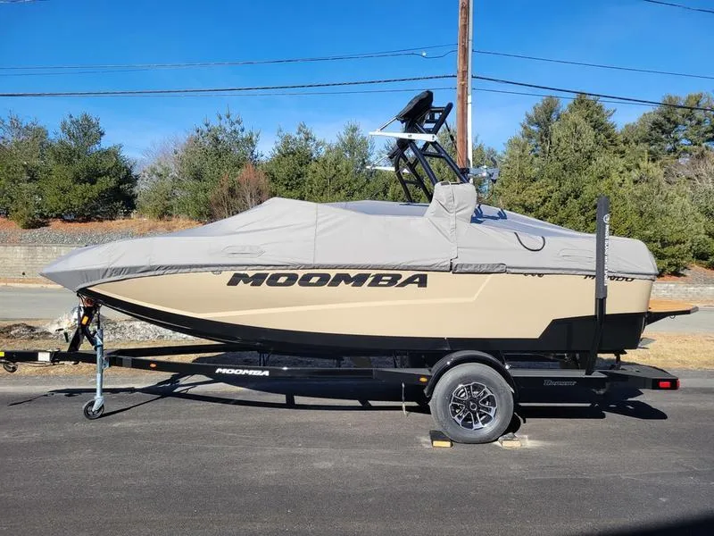 Slide: The Image of 2024 Moomba Mondo boat with cover on trailer, parked outdoors. - 2