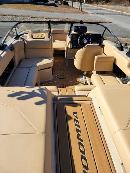 Slide: The Image of 2024 Moomba Mondo boat interior with beige seating and wood accents. - 29
