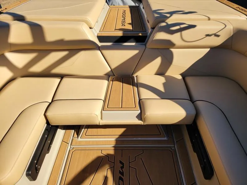 Slide: The Image of 2024 Moomba Mondo boat interior with beige seating and wooden accents. - 34