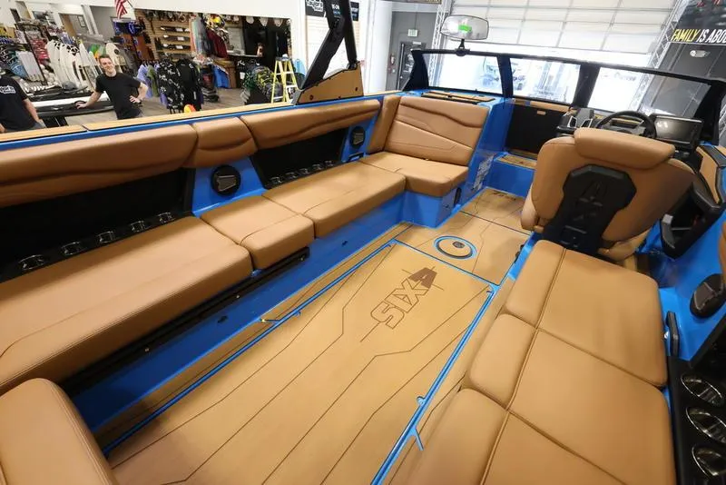 Slide: The Image of 2024 Axis T250 boat interior with tan leather seats and blue accents. - 12