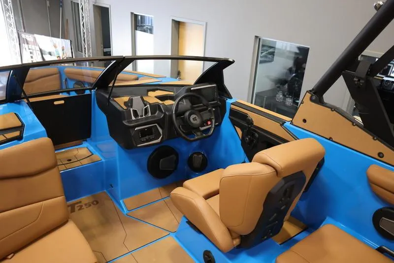 Slide: The Image of 2024 Axis T250 boat interior with tan leather seats and blue accents. - 13