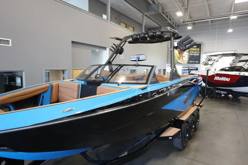 Slide: The Image of 2024 Axis T250 boat in showroom, blue and black exterior, tan interior. - 19