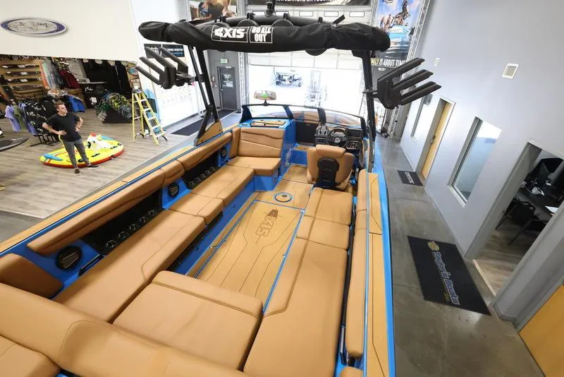 Slide: The Image of 2024 Axis T250 boat interior with tan seating in showroom. - 2