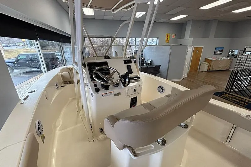 Slide: The Image of 2024 Scout 195 Sportfish boat interior with seating and outboard motor in showroom. - 14