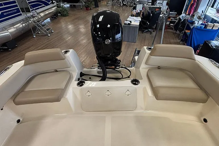 Slide: The Image of 2024 Scout 195 Sportfish boat with rod holders under showroom lights. - 15