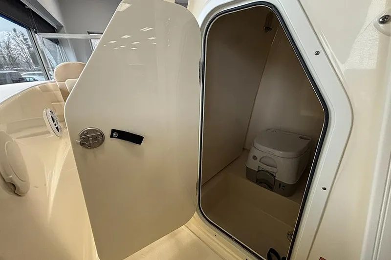 Slide: The Image of 2024 Scout 195 Sportfish boat interior with beige seating in showroom. - 18