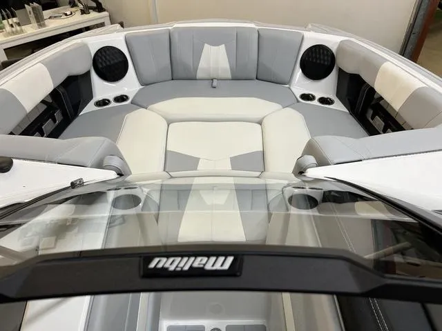 Slide: The Image of 2024 Malibu 24 MXZ boat interior with gray and white seating and cup holders. - 10