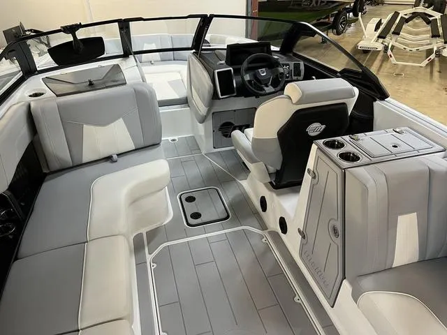 Slide: The Image of 2024 Malibu 24 MXZ boat interior with sleek gray and white seating and modern dashboard. - 7