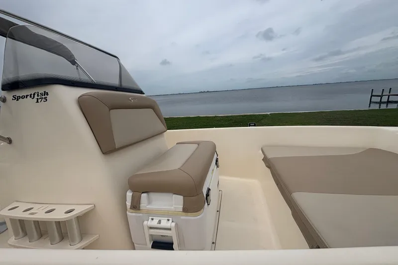 Slide: The Image of 2024 Scout 175 Sportfish boat interior with seating, near a calm waterfront. - 14