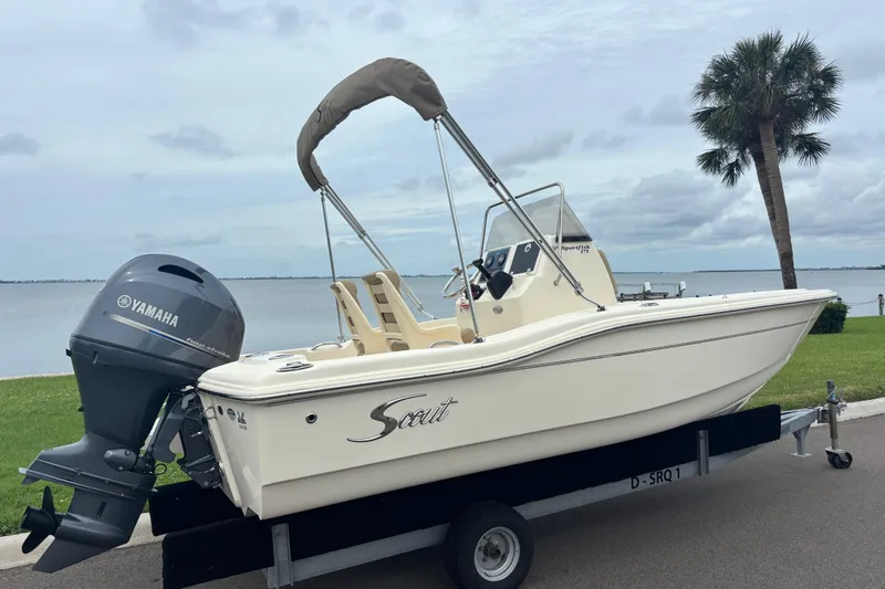 Slide: The Image of 2024 Scout 175 Sportfish boat with Yamaha engine on trailer by waterfront. - 2