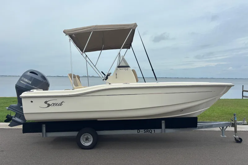 Slide: The Image of 2024 Scout 175 Sportfish boat with Yamaha engine on trailer by the water. - 4