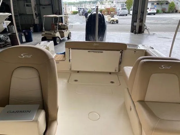 Slide: The Image of 2024 Scout 215 Dorado boat interior with beige seating and Garmin equipment. - 10