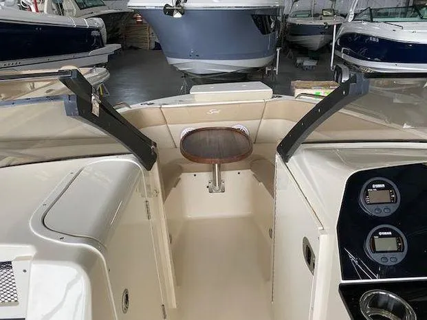 Slide: The Image of 2024 Scout 215 Dorado boat interior with seating and dashboard in showroom. - 6