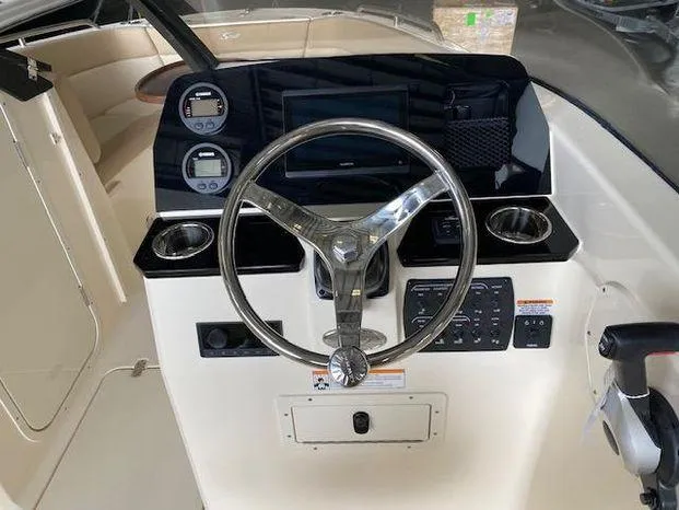 Slide: The Image of 2024 Scout 215 Dorado boat dashboard with steering wheel and control panel. - 8