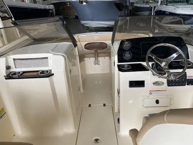 Slide: The Image of 2024 Scout 215 Dorado boat interior with steering wheel and seating area. - 9